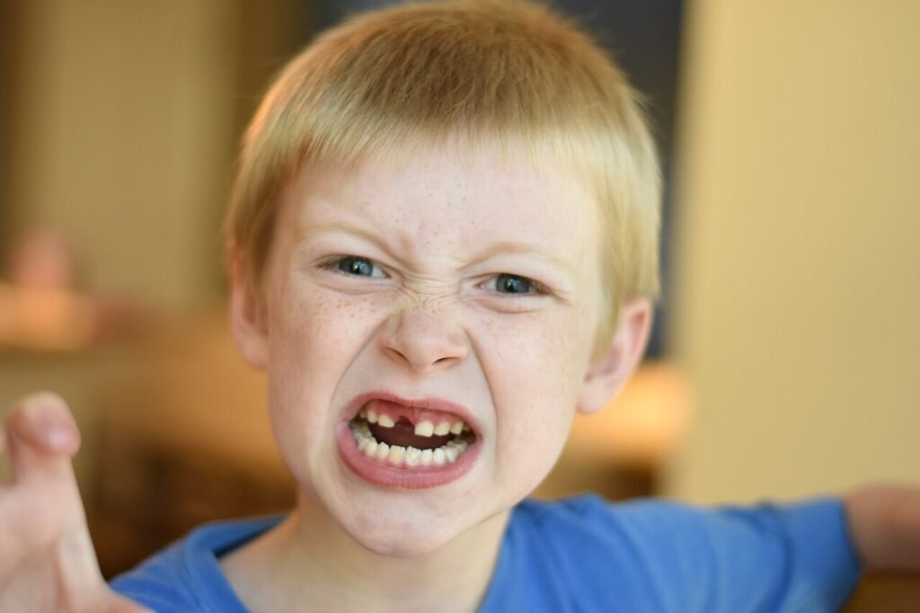 Upset child sitting with arms crossed, illustrating anger management for kids