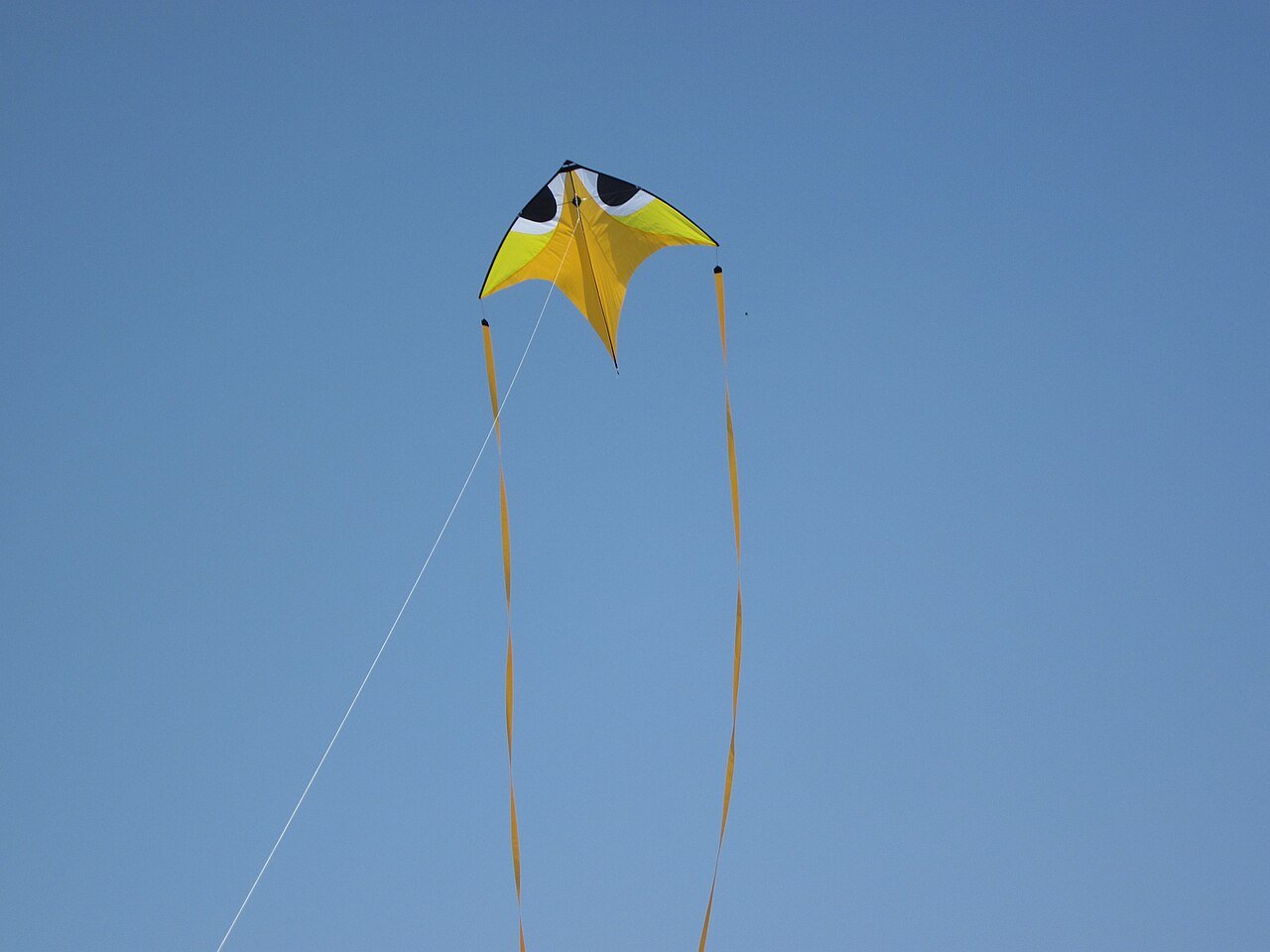 Colourful kite flying high in a blue sky, from a Sankranti story for kids