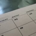 Calendar pages on a desk, illustrating the days of the week and months in Telugu