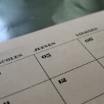 Calendar pages on a desk, illustrating the days of the week and months in Telugu