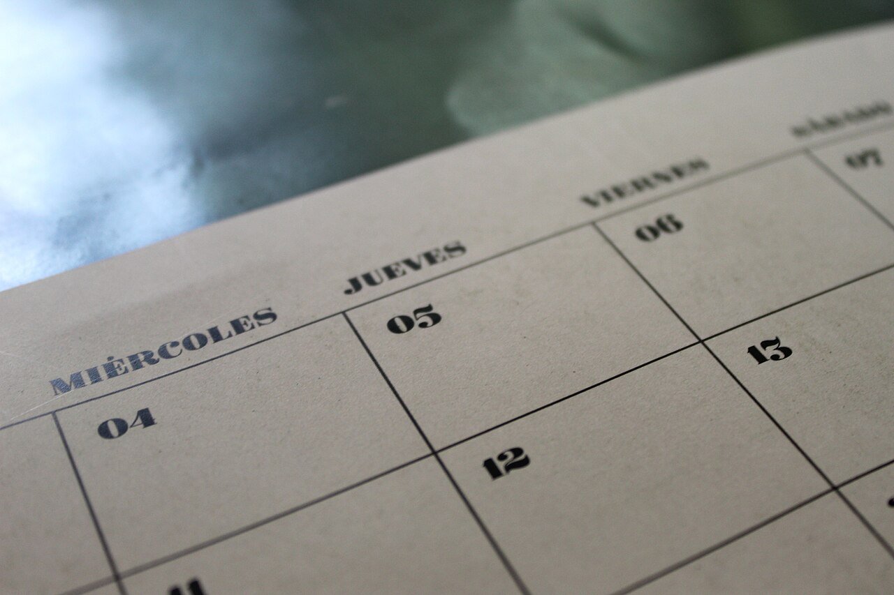 Calendar pages on a desk, illustrating the days of the week and months in Telugu