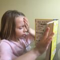 Young child reading a picture book, showing how to build a reading habit in kids
