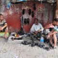 Traditional cobbler repairing shoes on a street, from a short story about contentment for kids