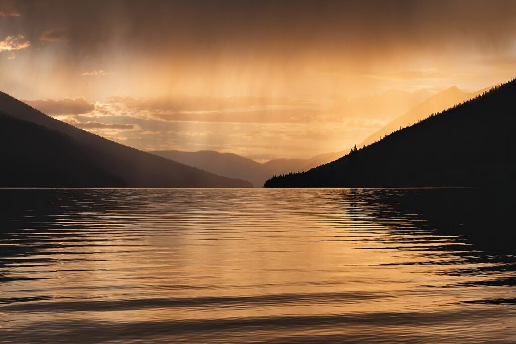 Rain clouds over a lake showing the water cycle for kids