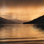 Rain clouds over a lake showing the water cycle for kids