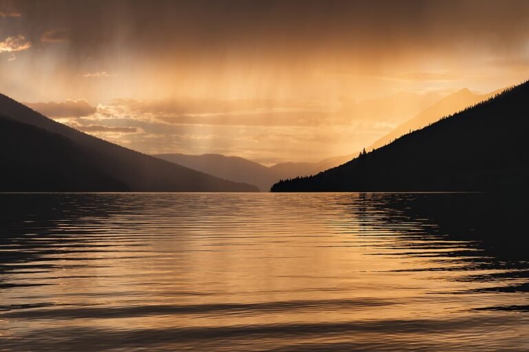 Rain clouds over a lake showing the water cycle for kids