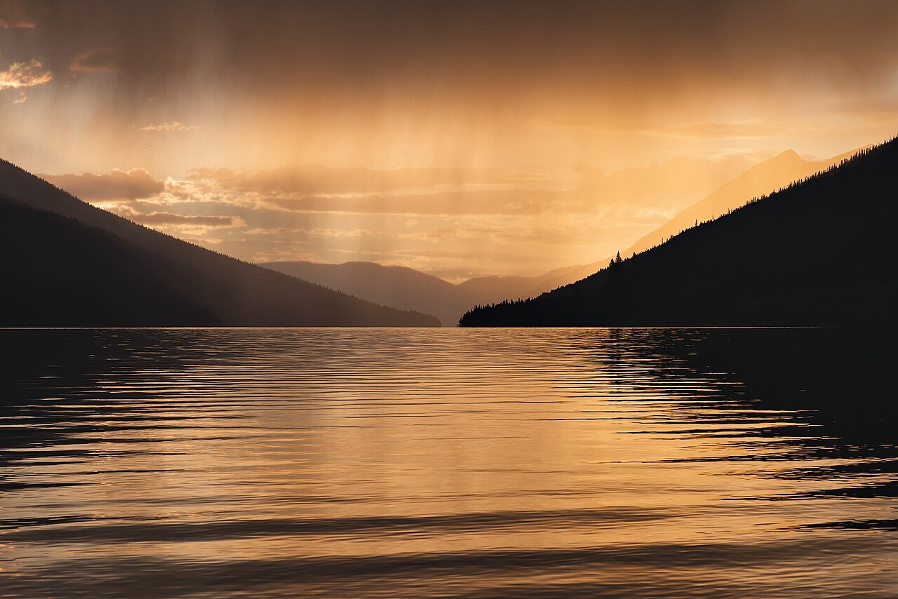 Rain clouds over a lake showing the water cycle for kids